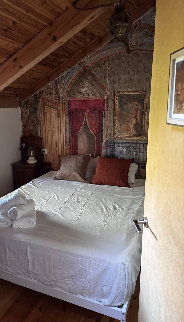 Dormitorio con mural de castillo y alcoba con cortinas