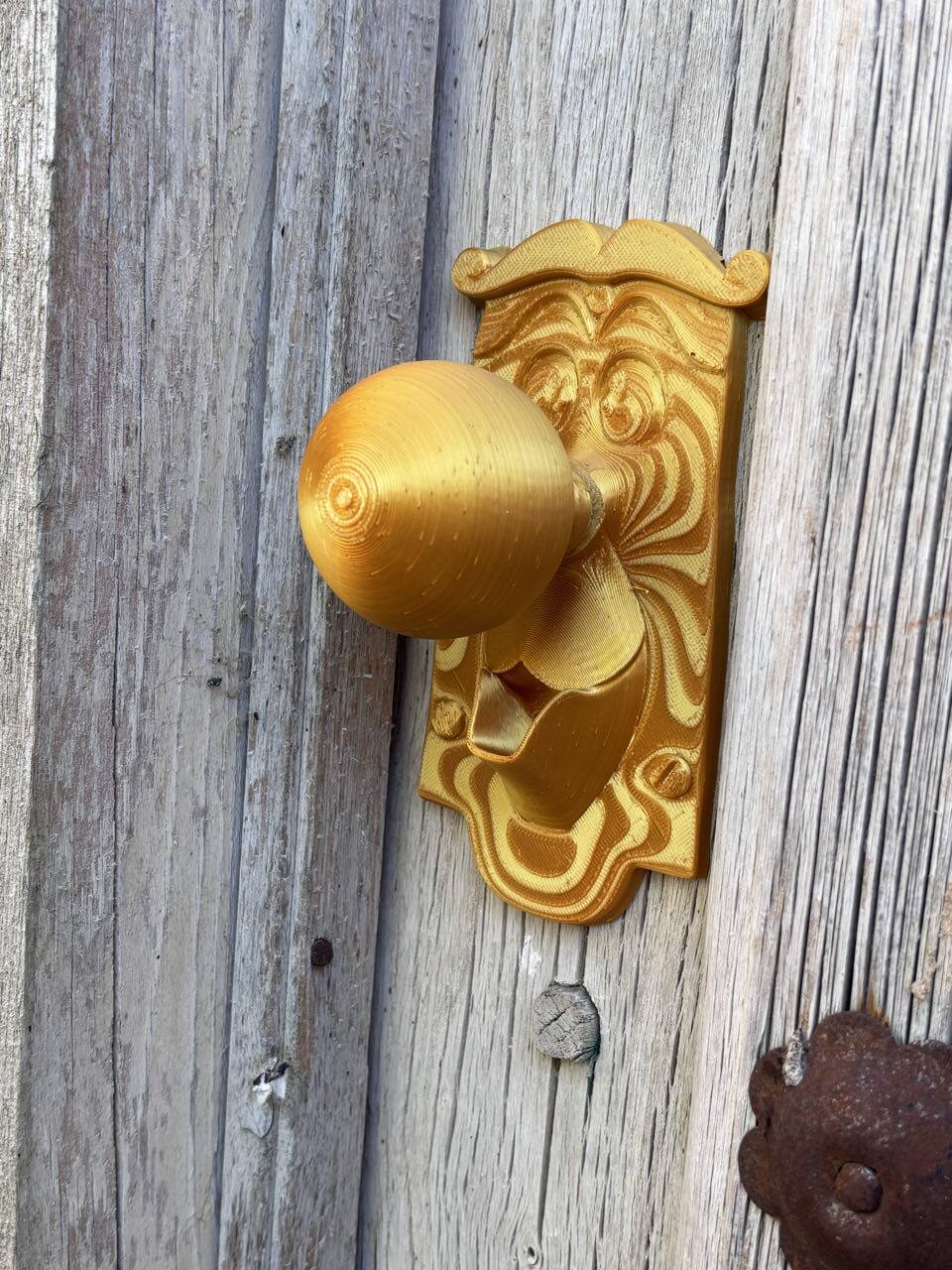 Detalle del tirador de la puerta dorado tallado