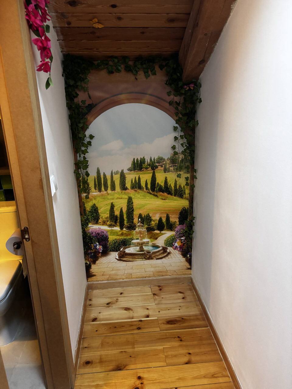 Pasaje en trampantojo que se abre a un jardín toscano pintado